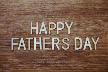 Happy Fathers Day text message on wooden background