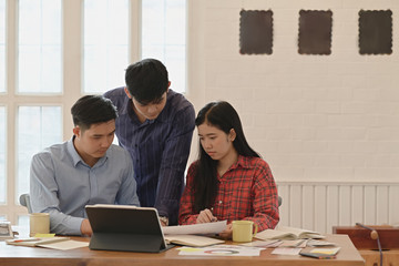 Team creative working on project together and discussing details in conference workshop