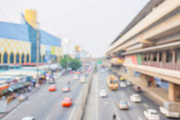 Blurry car driving on the road and sky train stations.