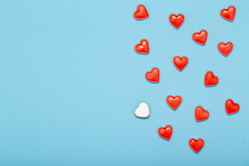 Concept of love, top view of red hearts on pastel blue background with copy space in minimal style, greeting card template.