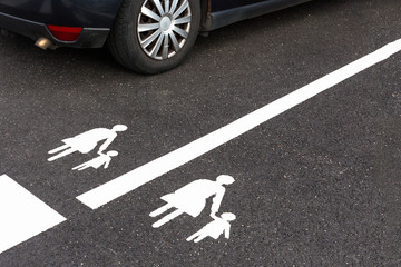 Family parking space sign with car.