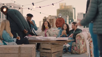 happy rooftop party friends drinking alcohol having fun on weekend social gathering chatting sharing pizza enjoying hanging out together at sunset