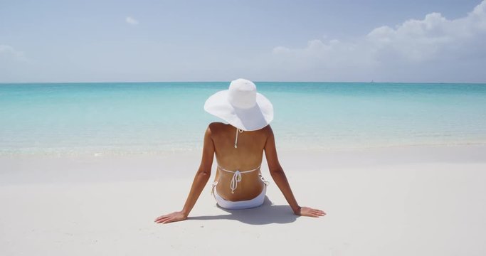 Beach sun travel vacation holidays. Woman on white sand paradise beach.