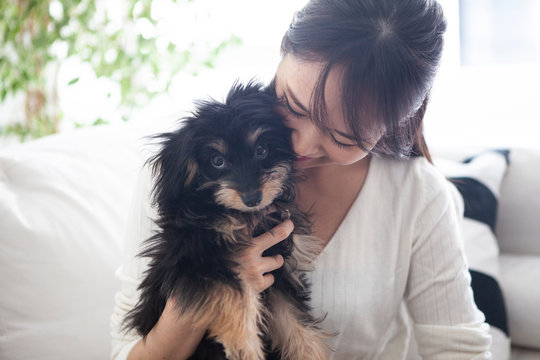 小さな子犬を大切に抱える女性