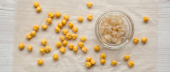 Fototapeta na wymiar Peeled chickpeas for cooking hummus, overhead view. Flat lay, from above. Close-up.
