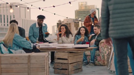 happy rooftop party friends drinking alcohol having fun on weekend social gathering chatting sharing pizza enjoying hanging out together at sunset - Powered by Adobe