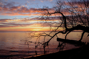 Sunset over the sea, clouds are illuminated in orange
