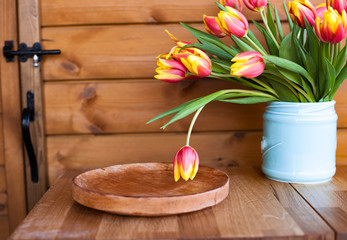 Bouquet of red-yellow tulips, Fresh flowers in a vase. Wooden background and space for text. Postcard.