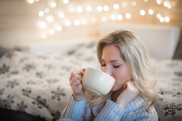 Beautiful blonde young woman relaxing in cozy mountain cabin