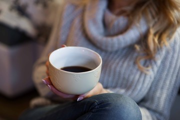 Beautiful blonde young woman relaxing in cozy mountain cabin