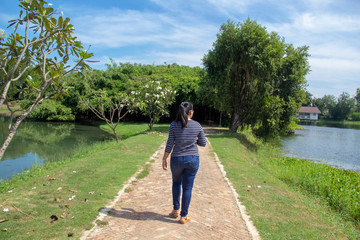 Fototapeta na wymiar woman walking in the park with blue sky