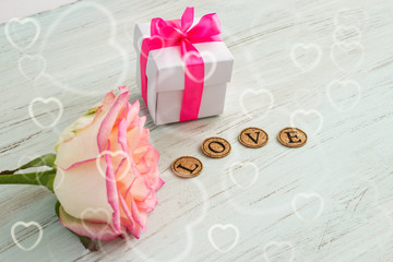 Valentine's day background. Flower rose, box with gift and inscription love with place for text.