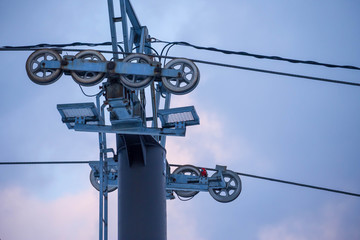 Closeup of wheels supporting cables for ski lift against sunset sky