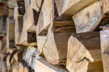 Natural wooden background. Firewood stacked and prepared for winter. Selective focus on a center