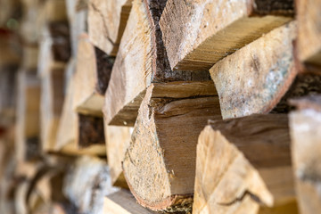 Natural wooden background. Firewood stacked and prepared for winter. Selective focus on a center