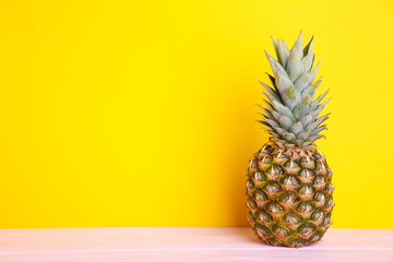 Ripe pineapple on a yellow background with copy space