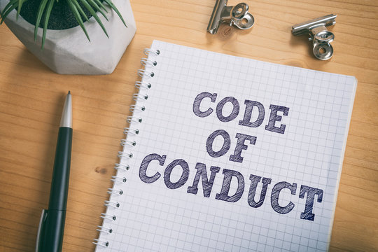 Code of Conduct text on notebook. Concept of ethical integrity, value and ethics.