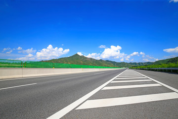 Fototapeta premium Highway, under the background of blue sky and white clouds