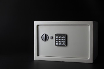 modern white steel money bank safe on a dark background with a coded lock