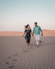 couple walking during sunset in the desert sand dunes of Maspalomas Gran Canaria, Maspalomas desert...