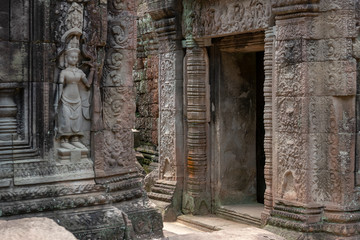 Fototapeta na wymiar Decorated stone entrance to temple opposite statue