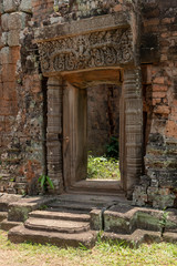 Fototapeta na wymiar Doorway to stone temple with decorated pediment
