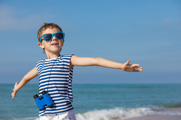 One happy little boy playing on the beach at the day time.