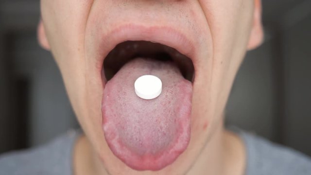 Close up of man puts the pill in his mouth
