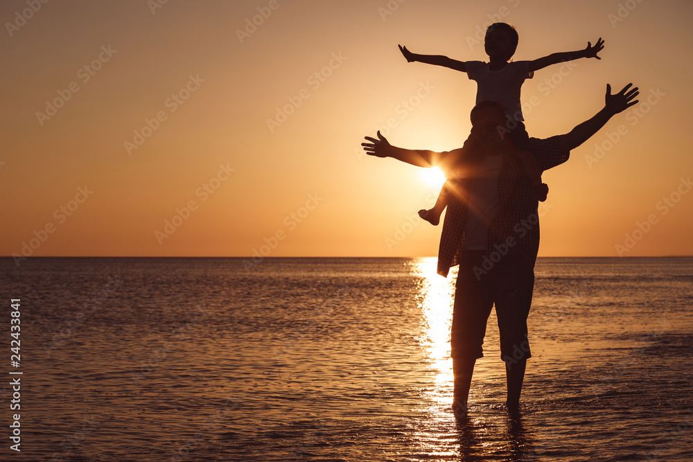 Canvas Prints father and son playing on the beach at the sunset time.