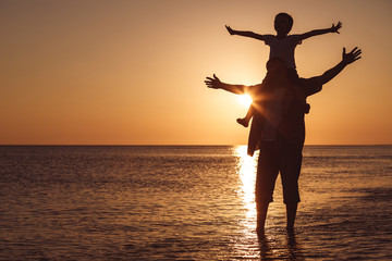 Fototapeta premium Father and son playing on the beach at the sunset time.