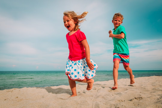 happy little girl and boy play run enjoy beach vacation
