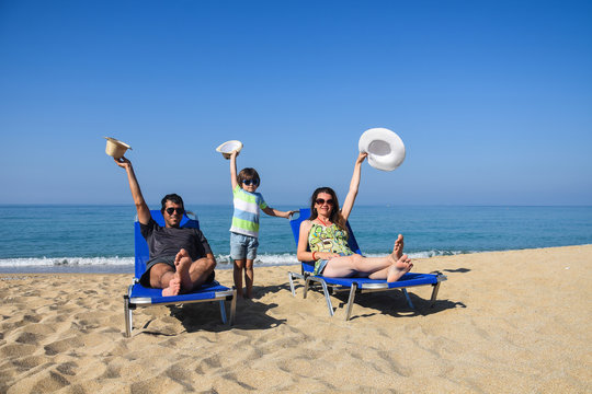 Happy family enjoy  in deck chairs on the beach during summer vacations