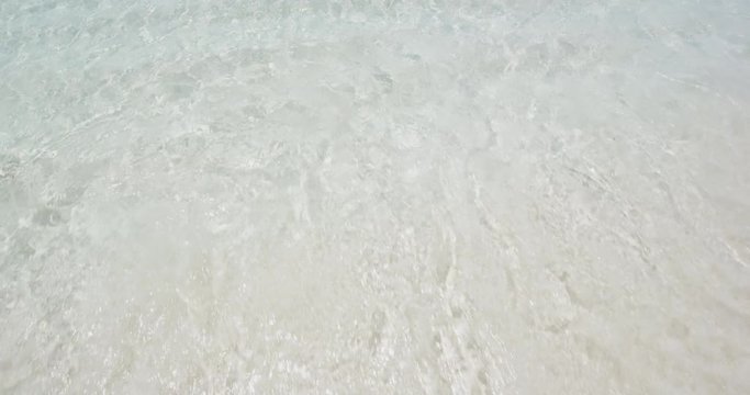 Beach body woman sun bathing on travel vacation. Sexy bikini body woman relaxing sun tanning lying down sunbathing on perfect paradise beach at tropical luxury destination in the Caribbean.