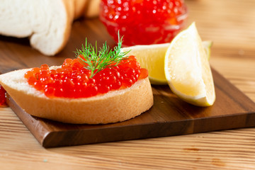 red caviar in glassware on a wooden background in a rustic style with space for text
