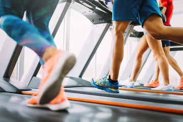 Healthy man and woman running on a treadmill in a gym
