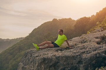 Sportsman watching tropical landscape after workout on a hill.