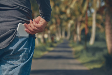 Man checking / taking his smart phone out of the back pocket.