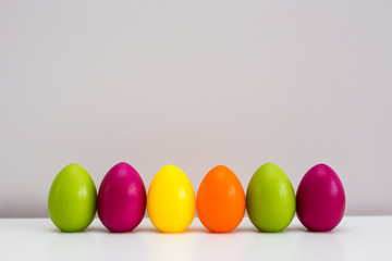 Easter background - close up of colorful eggs and copy space over wall