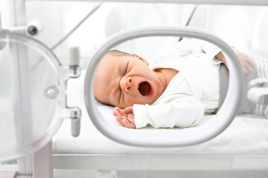 Noworodek w inkubatorze.  Nowonarodzone dziecko w inkubatorze na oddziale szpitalnym.