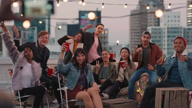 multi ethnic group of friends posing for photo on rooftop party at sunset students enjoying weekend gathering in urban city