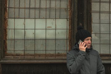 Serious woman talking on mobile phone on street in winter