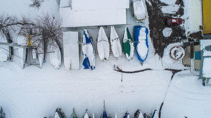 winter st&auml;ndig sail boats on ground , lot of snow , top view , drone shoot 