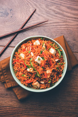 Schezwan paneer fried rice with Szechuan sauce and cottage cheese cubes. served in a bowl or plate or pan. selective focus