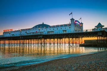Foto auf Acrylglas Brighton Pier beach with sunset golden hour at Sussex England, UK. Brighton Marine Palace and Pier popular place for visitor. © wittayayut
