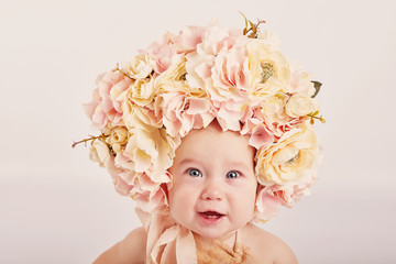 cute baby with flowers on a light background	