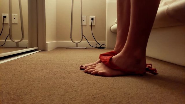Red knickers are dropped down legs to feet, suggestively