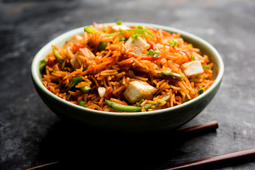 Schezwan paneer fried rice with Szechuan sauce and cottage cheese cubes. served in a bowl or plate or pan. selective focus