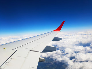 Obraz premium wing of an airplane flying above clouds