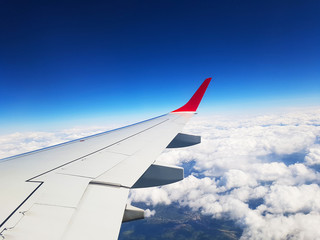 Obraz premium wing of an airplane flying above clouds