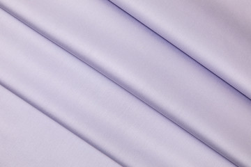 Lilac sateen fabric is laid by equal folds on diagonal